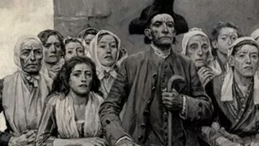 A group of people gathered closely, with one person standing in front holding a cane.
